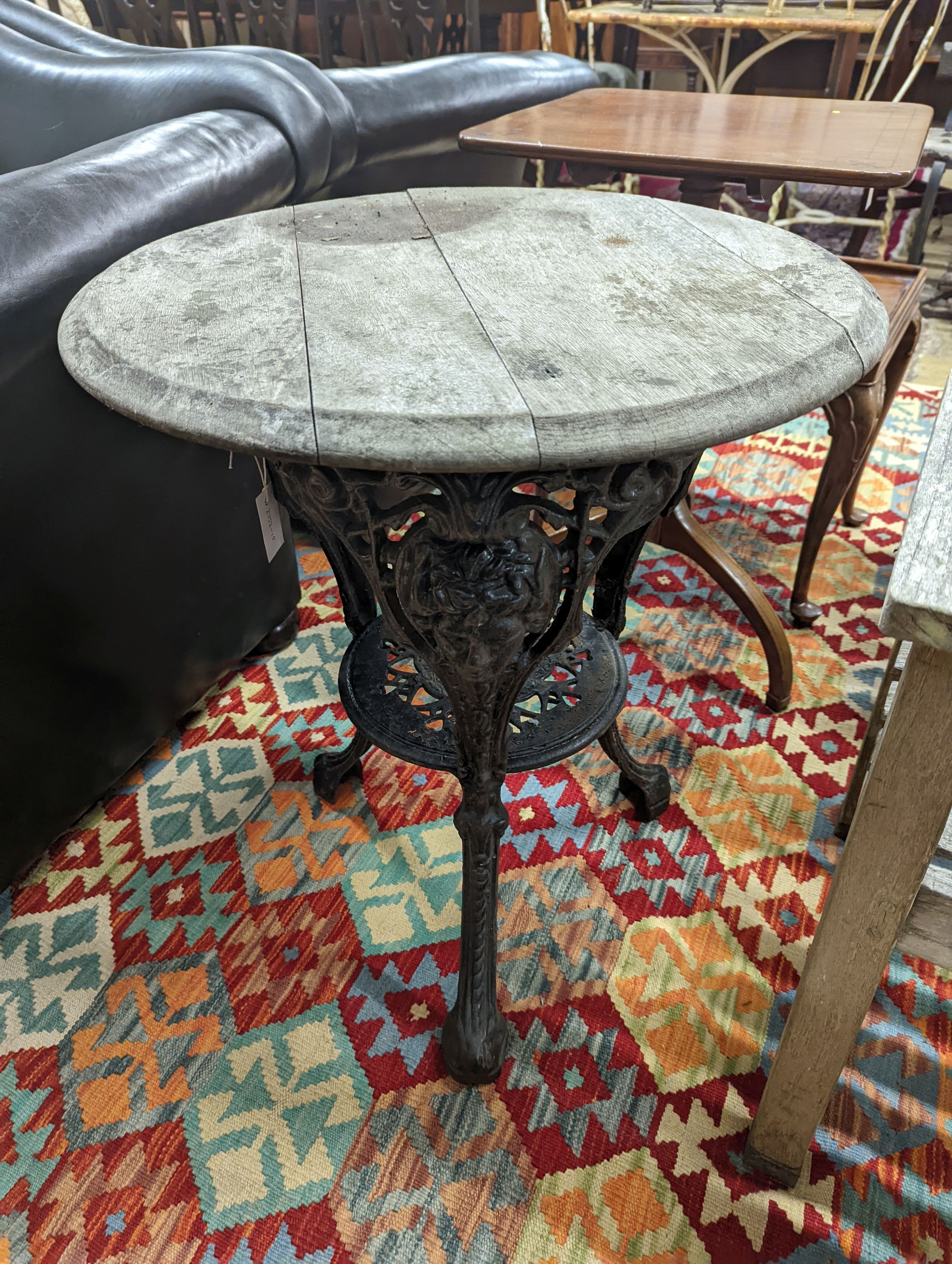 A Victorian cast iron Britannia table with circular weathered wood top, diameter 58cm, height 69cm